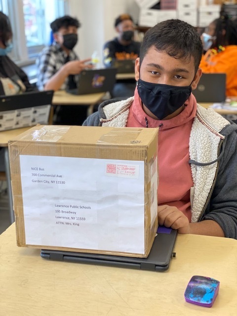 8th grader Aiden Maldonado receives package from NICE bus company